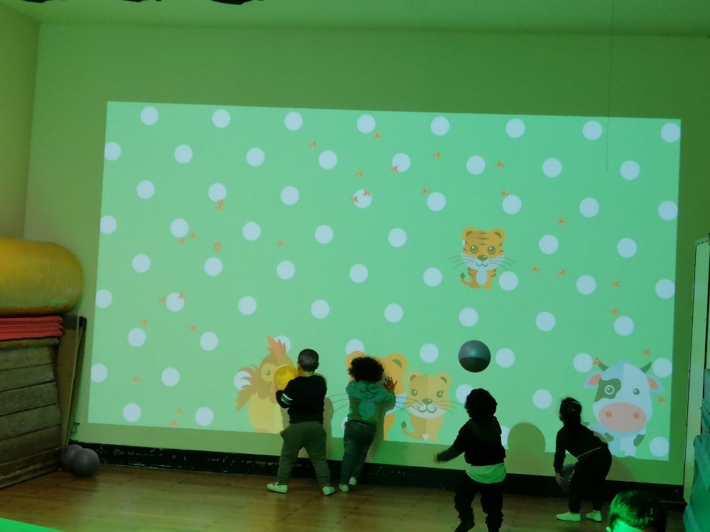 Des enfants devant un mur interactif